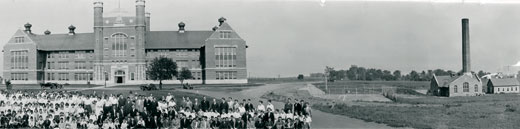 Partial Panorama image of the faculty, staff and students at Northwest with the Administration Building and Powerhouse in the background.  Included alumni from the first graduating class.