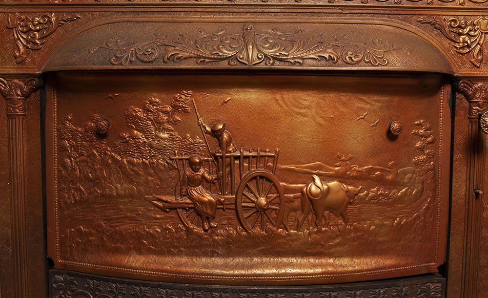 A photo of an elaborate cast copper pictorial firebox closure inside the Gaunt House.