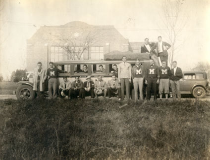 The 1931-1932 MIAA Champion Basketball Team poses outside the first gymnasium (now Martindale Hall) with their coach Henry Iba.