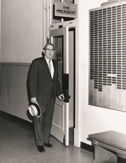 "Roll of Honor" Valk - Northwest's sixth president, J.W. Jones, stands outside his office in the Administration Building. The World War II Roll of Honor is displayed on the right. The Roll of Honor is now displayed in Valk Center.