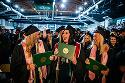 A group of graduates celebrate on the floor of Bearcat Arena Saturday after Northwest conferred their bachelor's degrees.