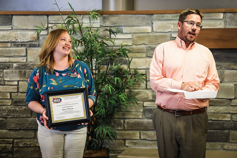 Selena Foreman, left, reacts Monday afternoon as Dr. Matt Baker, Northwest's vice president of student affairs, announces she is the recipient of state and regional Student Employment Supervisor of the Year awards. (Photo by Todd Weddle/Northwest Missouri State University)