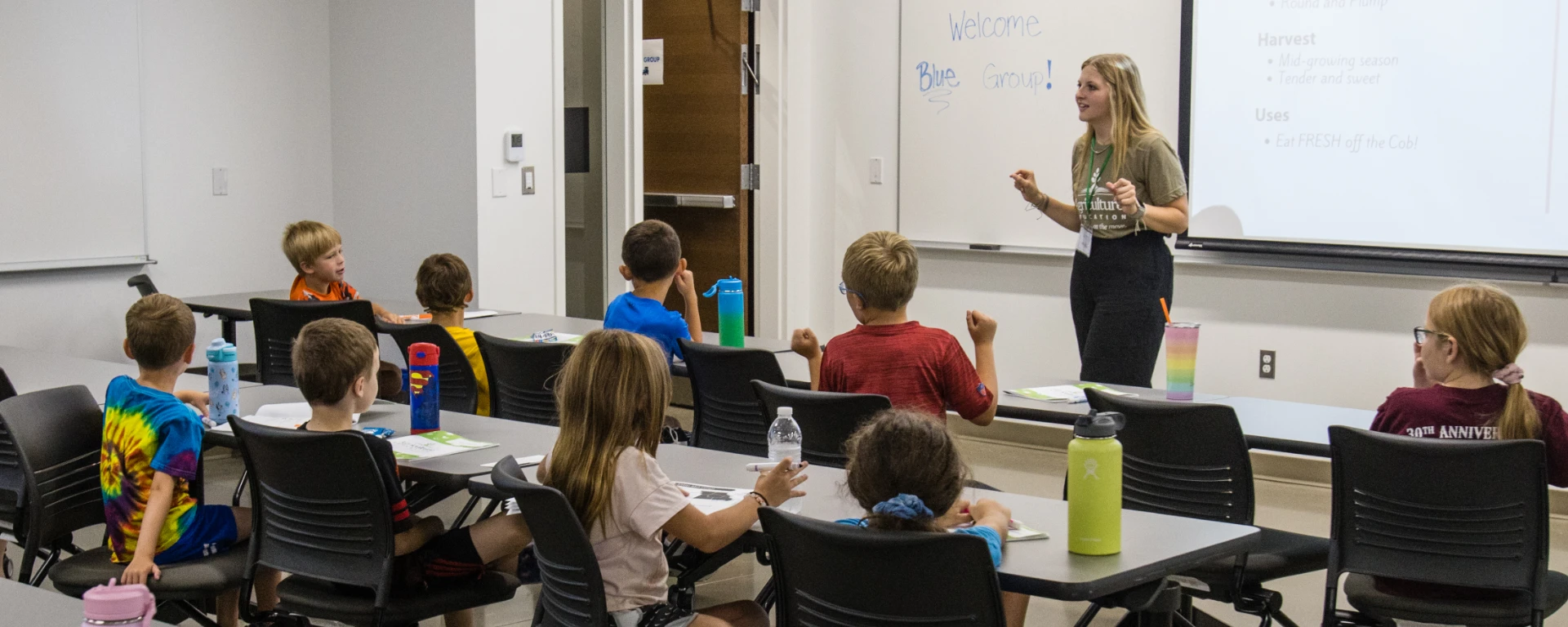 A young female ag teacher talks with a group of campers about where the food they eat comes from