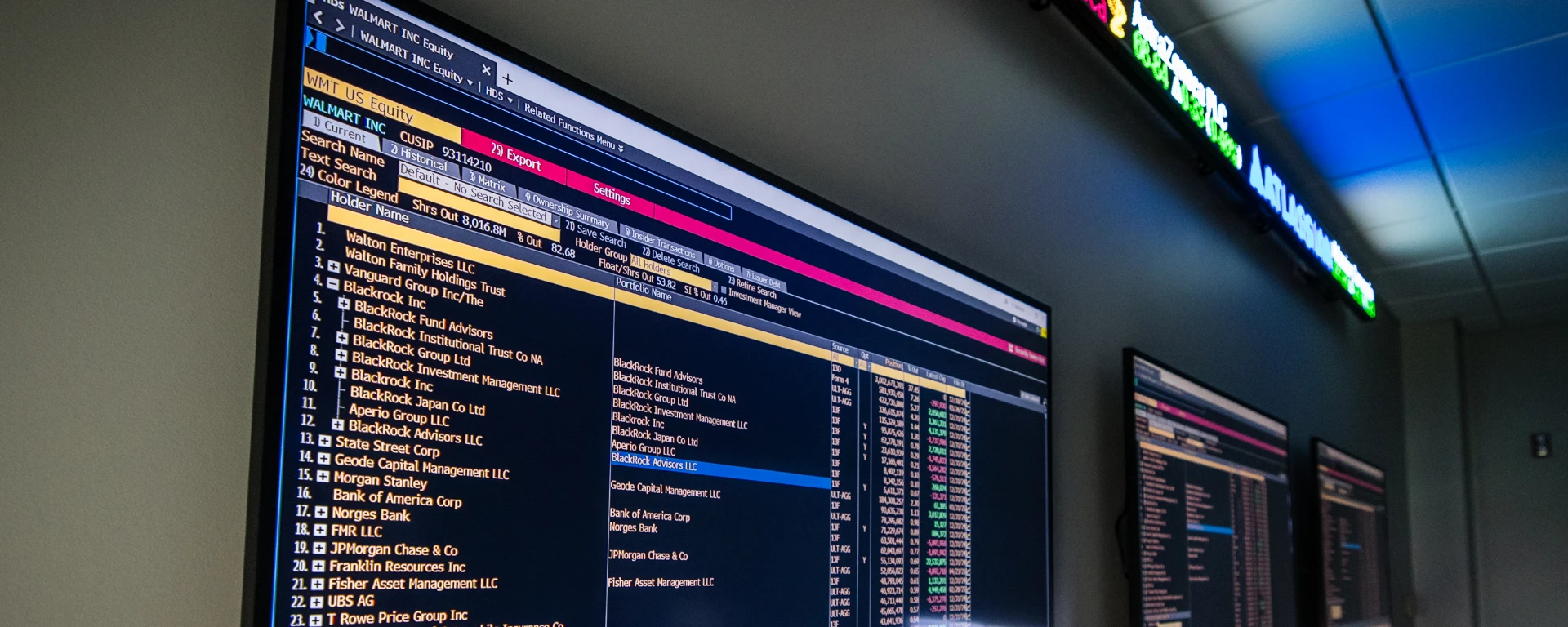 Closeup up the television monitors and a ticker display that enable students to track commodity and financial markets