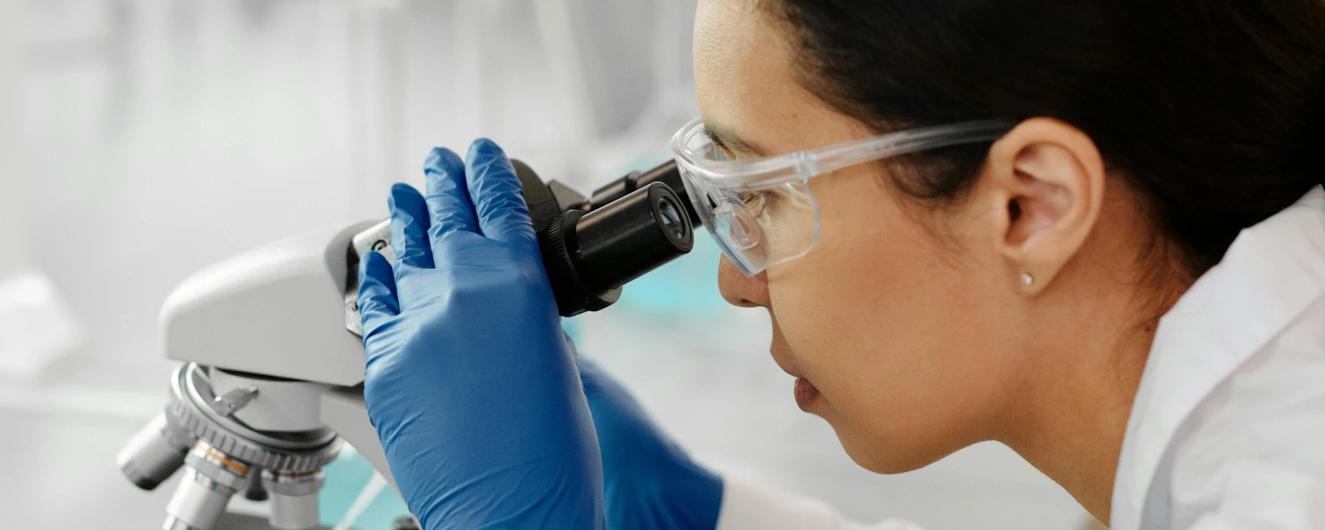 A digital forensics investigator uses a microscope to analyze evidence like firearms, toolmarks, and trace evidence.