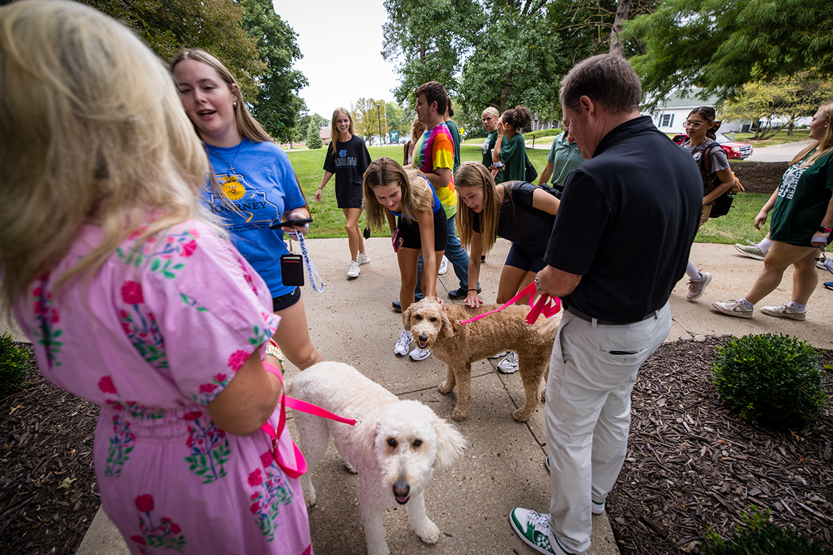 Northwest first lady Jill Tatum and President Dr. Lance Tatum, along with their dogs, greet students as they pass by the Gaunt House during annual March to the Tower on Aug. 21. (Photo by Lilly Cook | Northwest Missouri State University)