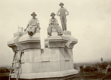 Construction workers hired by J.H. Felt & Co. take a break from their endeavors to pose for a picture on top of one of the Administration Building's signature crown-like turrets.