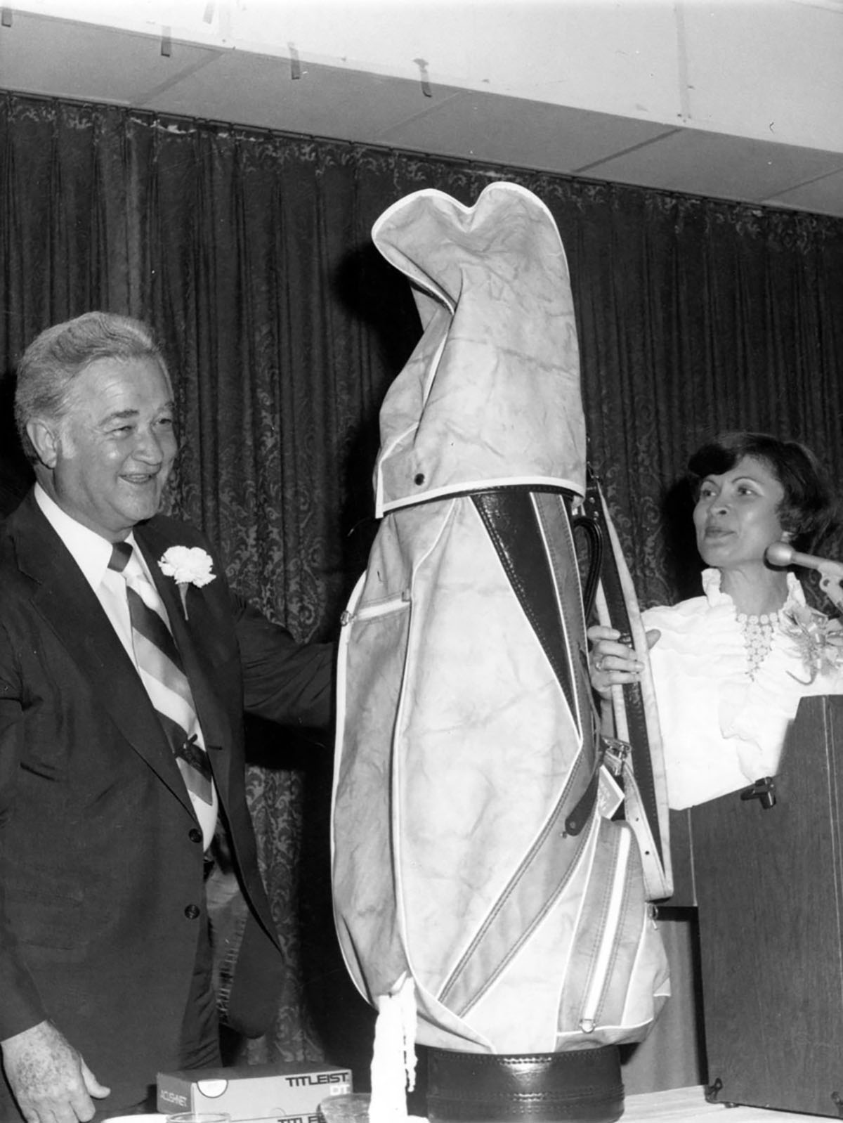 An avid golfer, Foster receives a retirement gift at a dinner in his honor in 1977. 