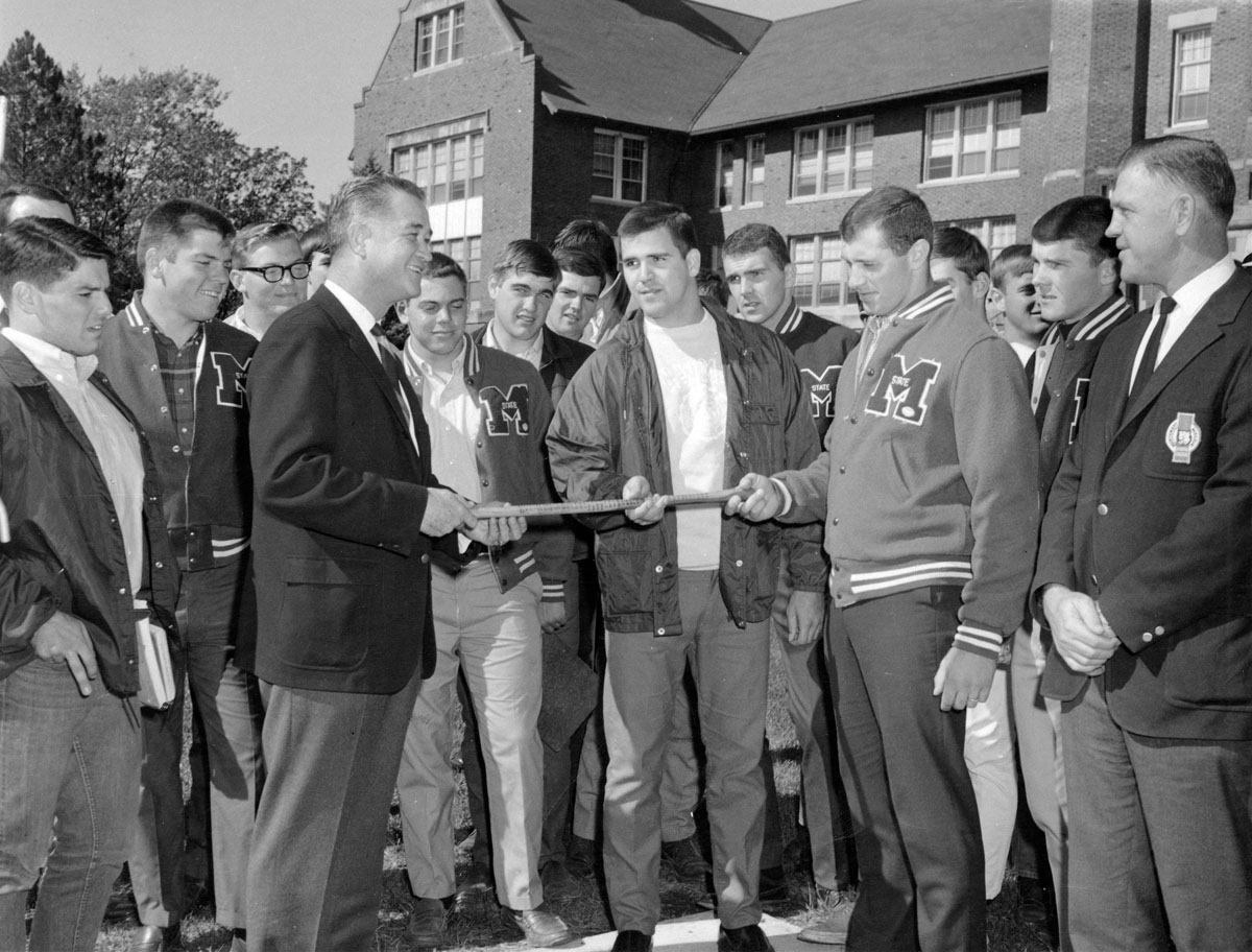 Foster receives the Old Hickory Stick after the Bearcat football team won it back from Northeast Missouri State University in 1969. 