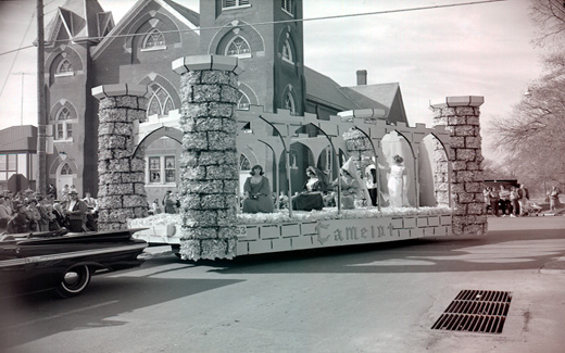 A Camelot float filled with lovely medieval-dressed Northwest students is paraded down a Maryville Street.  Camelot, due to the Kennedys and the musical, was a popular theme during the early 1960s.  Camelot, the musical about King Arthur, first appeared on Broadway in 1960.