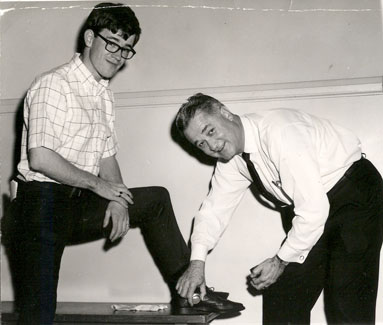 President Foster shines a student's shoes during the early 1960s during Parents' Day Activities.
