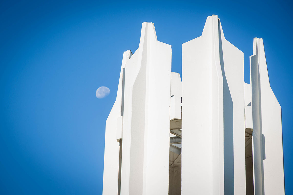 The Memorial Bell Tower stands against a blue sky on a fall morning.