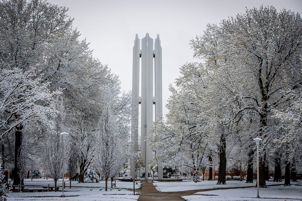 The Memorial Bell Tower is surrounded by snow-covered trees on a winter day.