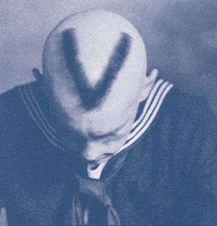 Navy V-5/V-12 Combat Information Center, Bearcat Stadium Room 109 - A sailor displays his Navy V-12 haircut. Men enrolled in the V-12 program were training to become deck officers and took courses in physics, chemistry, mathematics, pre-engineering, history, government, English and speech. A "Mark of Commendation" plaque is displayed on the Administration Building's third floor and Navy Combat Information Center classroom is in Bearcat Stadium, #109.