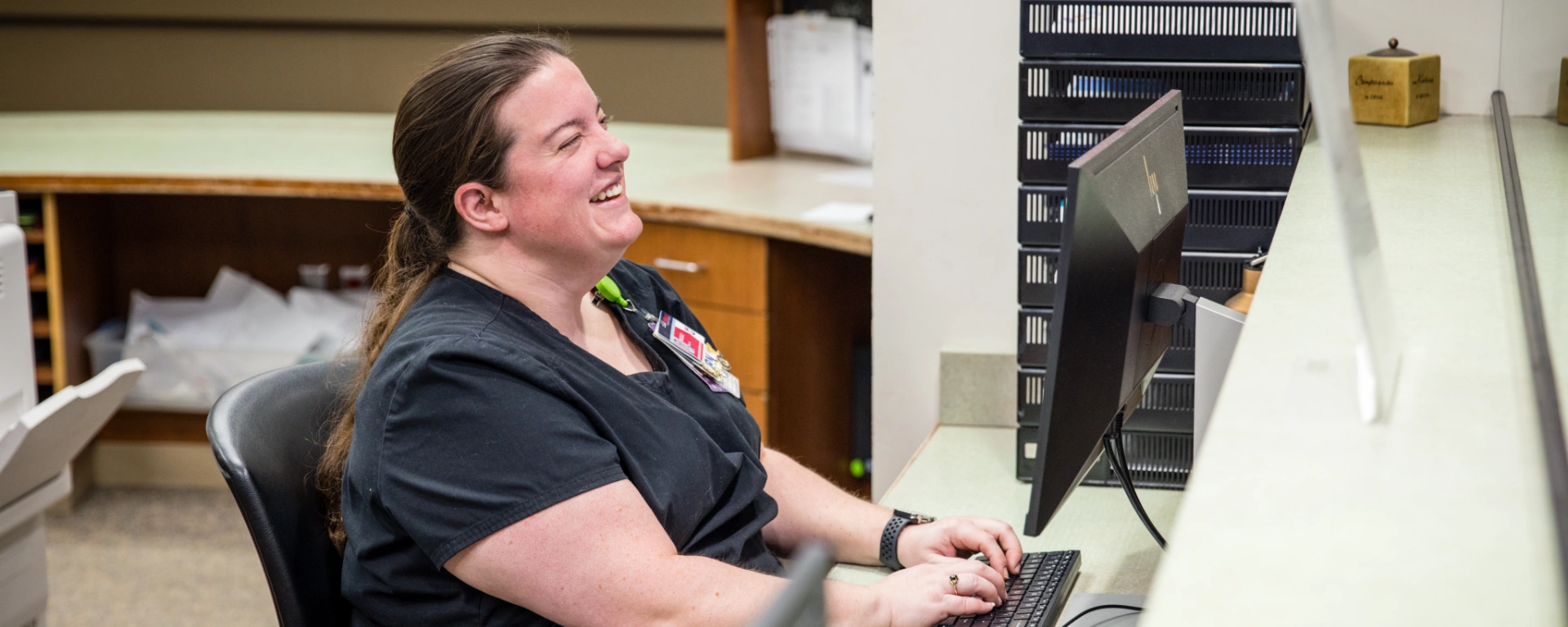 A public health worker greets patients with a smile at the reception desk