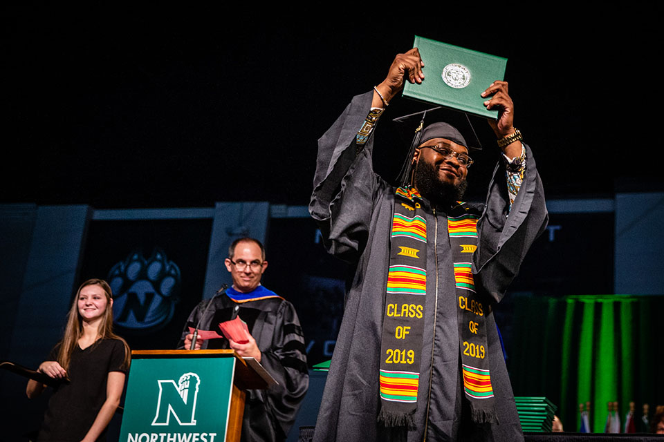 A Northwest graduate raises his diploma cover as he crosses the commencement stage Saturday. (Photos by Todd Weddle/Northwest Missouri State University)