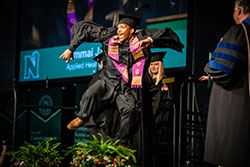 A student dances across the stage at Bearcat Arena on his way to receiving his bachelor's degree.