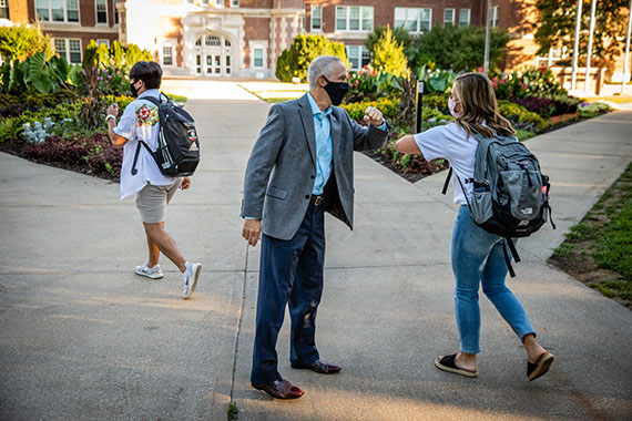 Northwest President Dr. John Jasinski bumped elbows with students Wednesday morning as they traveled to classes on the Northwest campus.