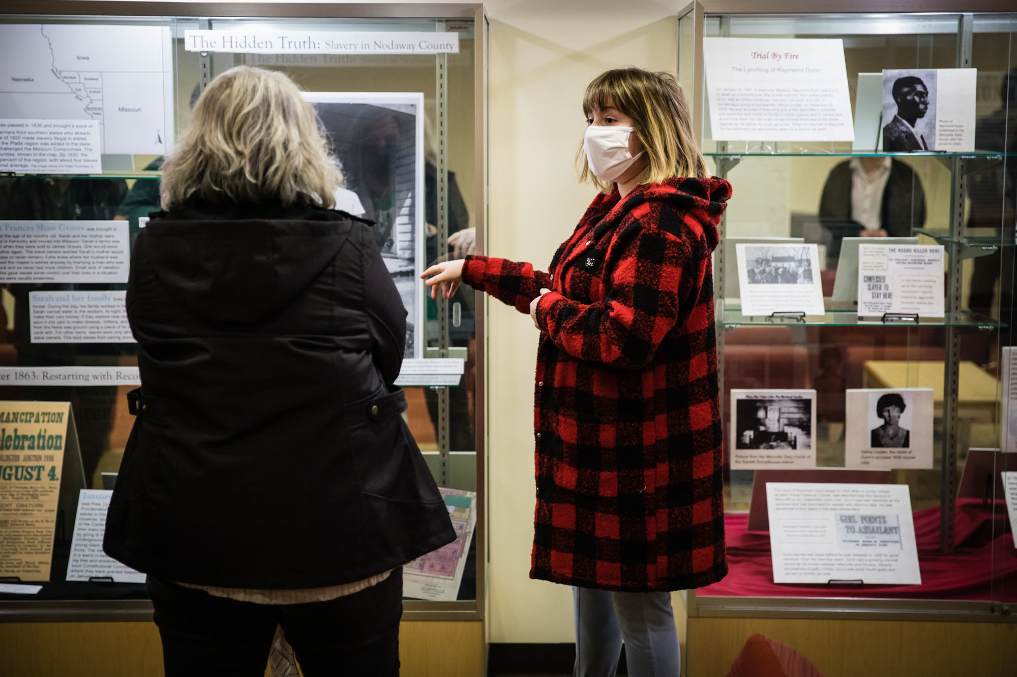 Northwest student Abigail Cottingham talks with a visitor about her research of slavery in Nodaway County. At right, a display case depicts details of Raymond Gunn's lynching in 1931. 