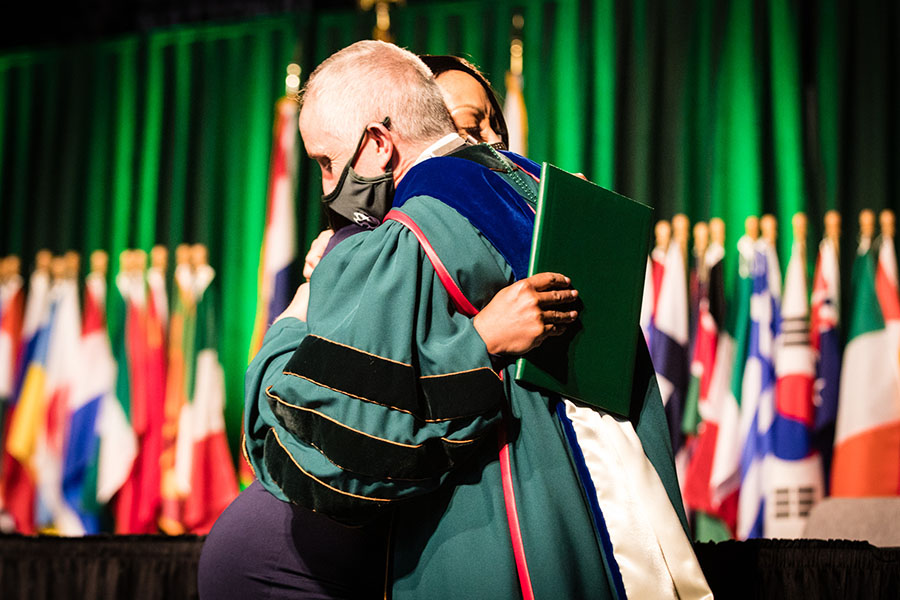 Northwest President Dr. John Jasinski embraces Kwanda Harrell during Northwest's commencement ceremony Saturday afternoon after she accepted a posthumous Bachelor of Science degree on her son’s behalf, (Photo by Brandon Bland/Northwest Missouri State University)