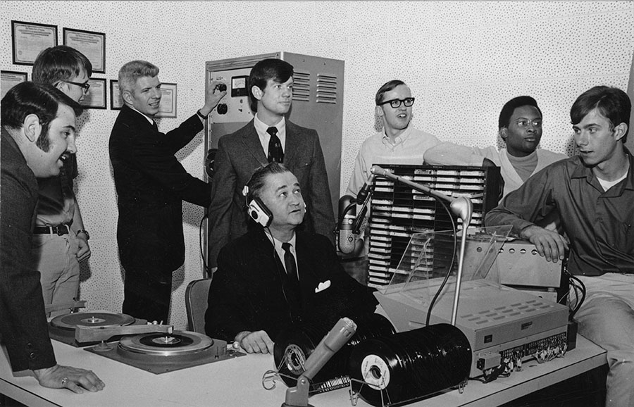 Northwest President Dr. Robert Foster (sitting at the center) joined Vinnie Vaccaro (far left) and other students and staff in the Administration Building's new radio studio for a demonstration. 