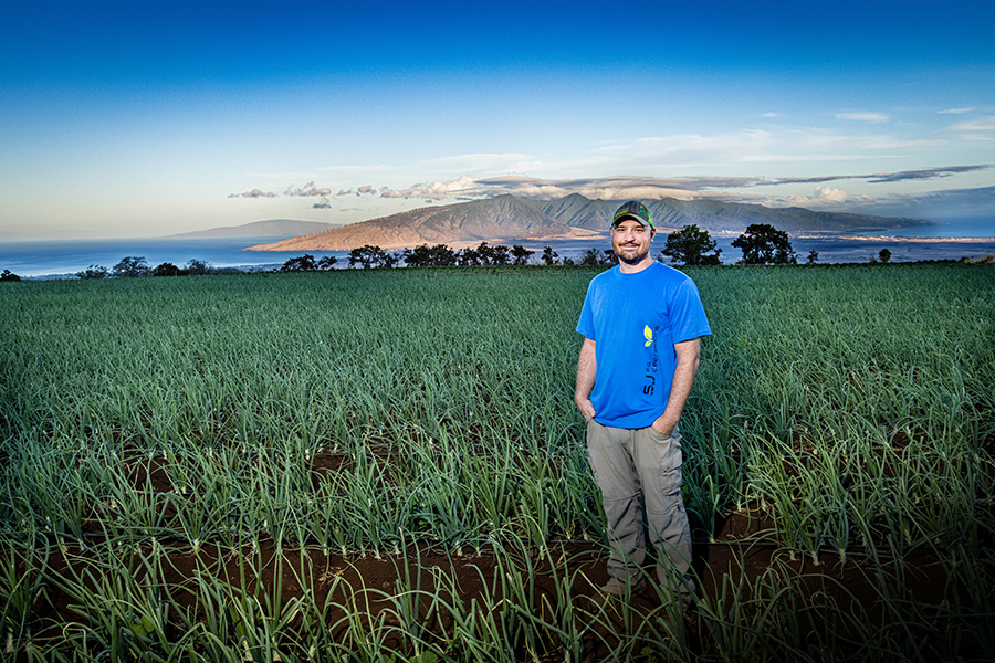 Shyloh Stafford-Jones stands in an onion field on Maui where he was scouting crops for a client. Through his business, SJ Ag Operations, Stafford-Jones consults with and assists farmers throughout the island.