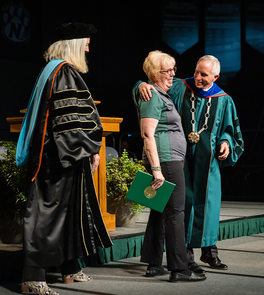 Provost Dr. Jamie Hooyman and President Jasinski greet Northwest alumna Jan Corley after inviting her to cross the commencement stage.