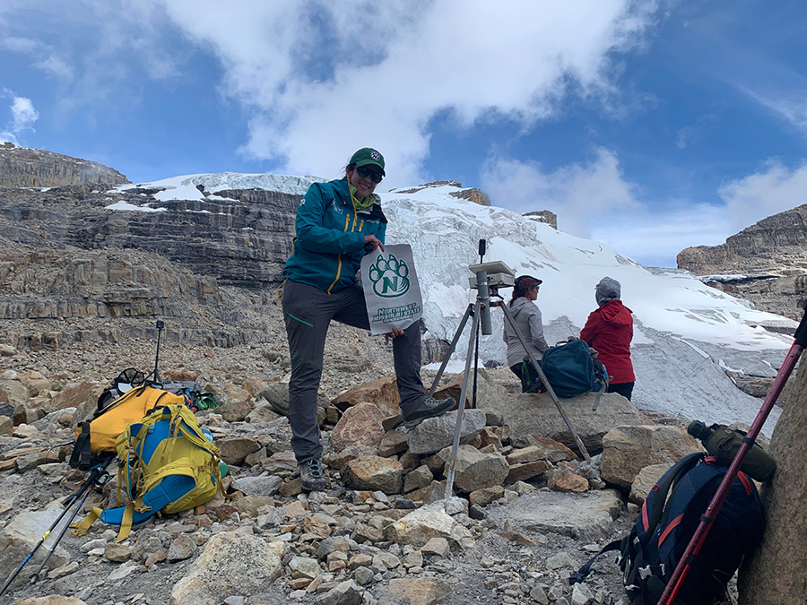Dr. Nina Adanin, an assistant professor of recreation, displays a Bearcat flag while conducting research of disappearing tropical glaciers in Colombia and Uganda. (Submitted photo) 