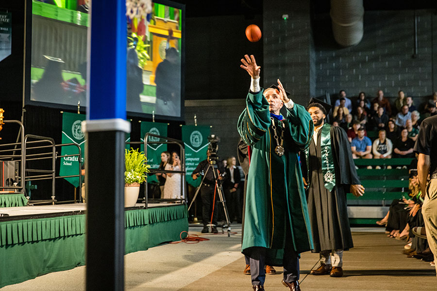 President Jasinski attempts a basketball shot Friday afternoon after he challenged men's basketball players Trevor Hudgins and Luke Waters to a shooting contest. (Photo by Todd Weddle/Northwest Missouri State University) 