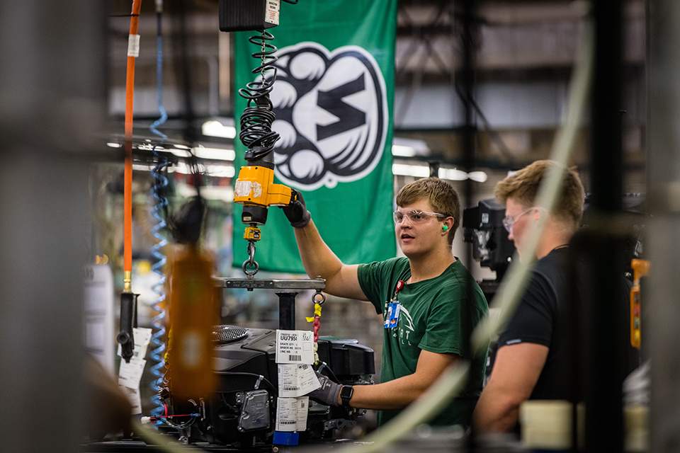 A Bearcat flag hangs above an assembly line at Kawasaki Motors Manufacturing Corporation in Maryville, where student-athletes worked this summer and helped strengthen the University's partnership with the engine plant. (Photos by Lauren Adams/Northwest Missouri State University) 