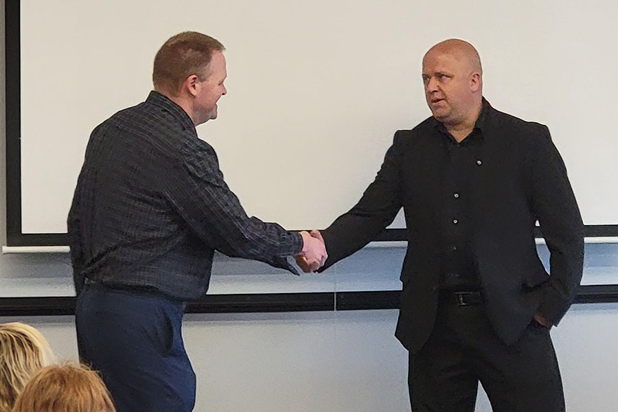 Dr. Ben Blackford, director of the Melvin D. and Valorie G. Booth School of Business (left), and Paul Janicek, owner of the DocuLock franchise, shake hands Wednesday as Northwest announced its partnership with DocuLock to offer franchise opportunities to students. (Submitted photo)