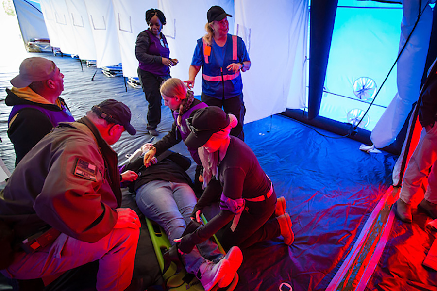 Medical personnel practice tending to a victim of a natural disaster inside a hospital tent at Missouri Hope.