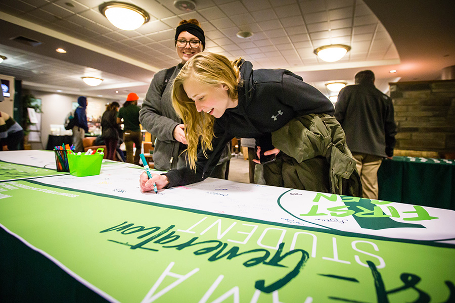 A Northwest student signs a banner celebrating first-generation college students during a previous First-Generation College Celebration at the University. (Northwest Missouri State University photo)