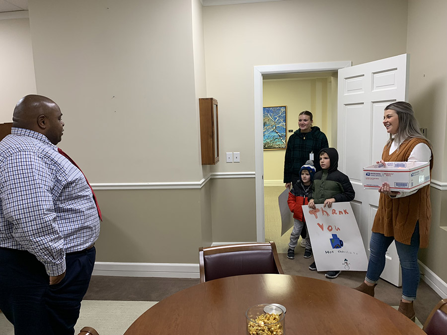 Northwest students Kelsey Maxwell and Maddie Stark, along with a pair of Horace Mann students, delivered hot cocoa mix to Northwest employees working in the Administration Building, including Interim President Dr. Clarence Green. (Northwest Missouri State University photo)