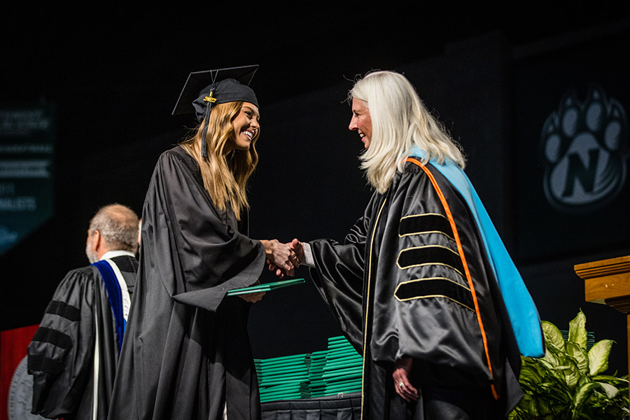 A graduating student receives a handshake from Northwest Provost Dr. Jamie Hooyman during one of the University's winter commencement ceremonies.  