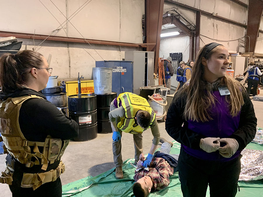 Sarah Gisinger (right), a University of Missouri-Kansas City nursing student, asks members of the Atlantica MNS to stay back during the Atlantic Hope crisis simulation as Eli Fox, a Northwest emergency and disaster management major, assists a victim in the background. (Northwest Missouri State University photos)