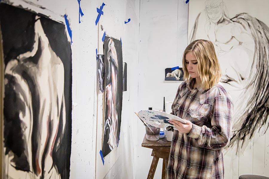 Caylea Dill is pictured painting this spring in her studio in the Olive DeLuce Fine Arts Building. (Photos by Chandu Ravi Krishna/Northwest Missouri State University