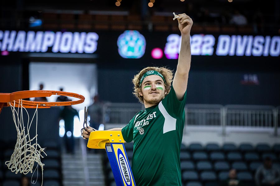 Jared Carlton cut a piece of the net as a representative of the Northwest Pep Band after the Bearcat men's basketball team won its fourth NCAA Division II  national championship in 2022 in Evansville, Indiana. (Photo by Todd Weddle/Northwest Missouri State University)