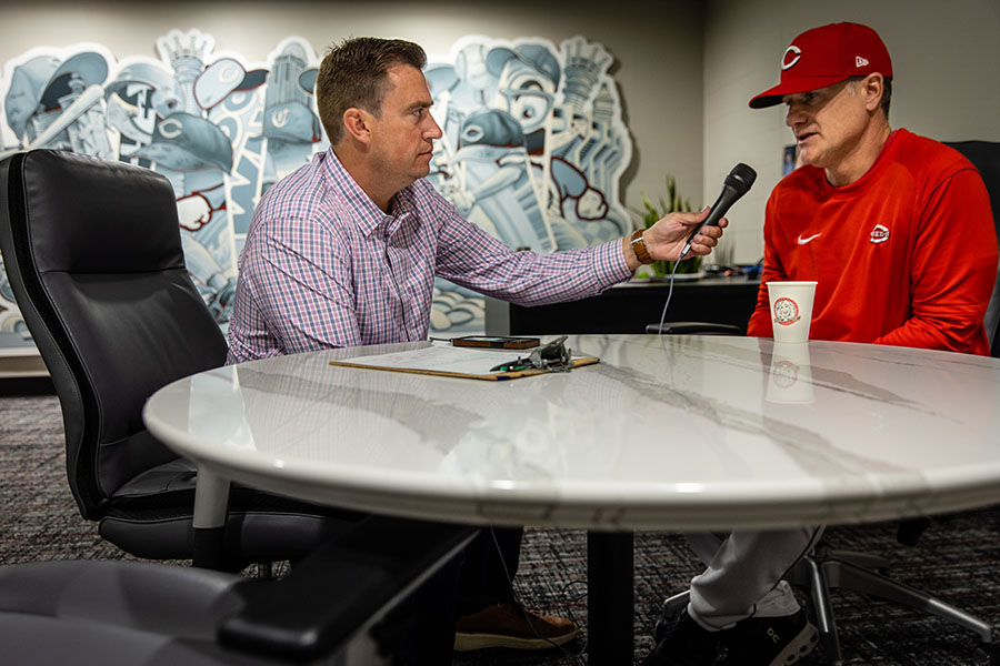 Tommy Thrall interviews Reds manager David Bell prior to a game.