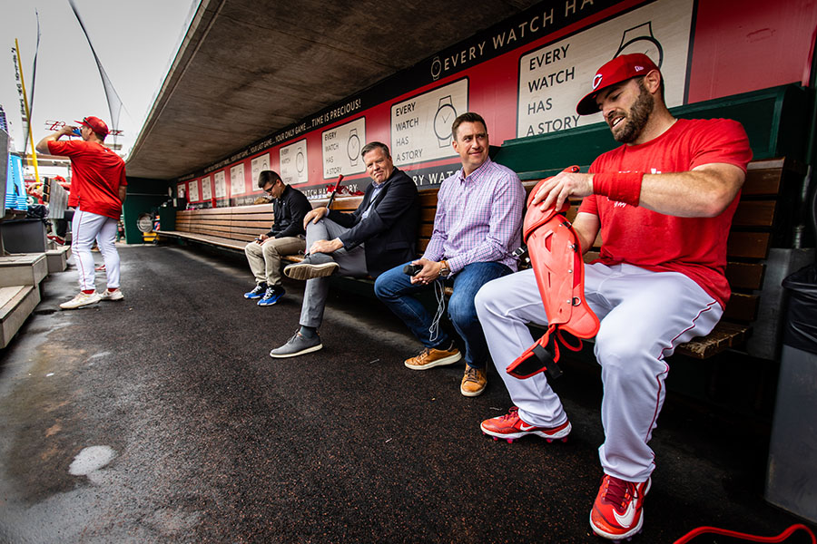 Tommy Thrall chats with Cincinnati catcher Curt Casali in the Reds' dugout before a game.