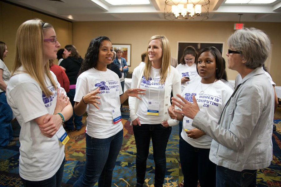 Dr. Carol Spradling, right, converses with women at the biannual Missouri Iowa Nebraska Kansas Women in Computing Conference, which she co-founded.