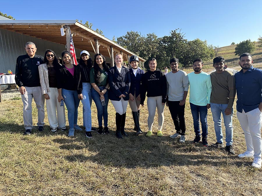 Eight graduate students from the School of Computer Science and Information Systems recently created a web application for the Regional Intercollegiate Horse Show Association. The students are pictured while attending a horse show with Dr. Aziz Fellah, associate professor of computer science and information systems (left), and horse show participants. (Submitted photos)