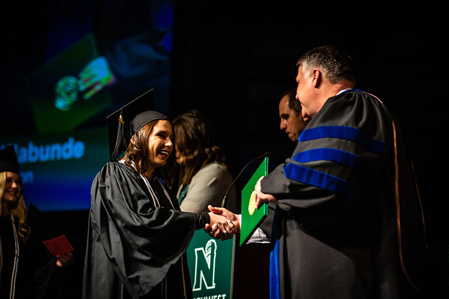 A Northwest graduate crosses the stage in Bearcat Arena during a commencement ceremony. (Northwest Missouri State University photo)