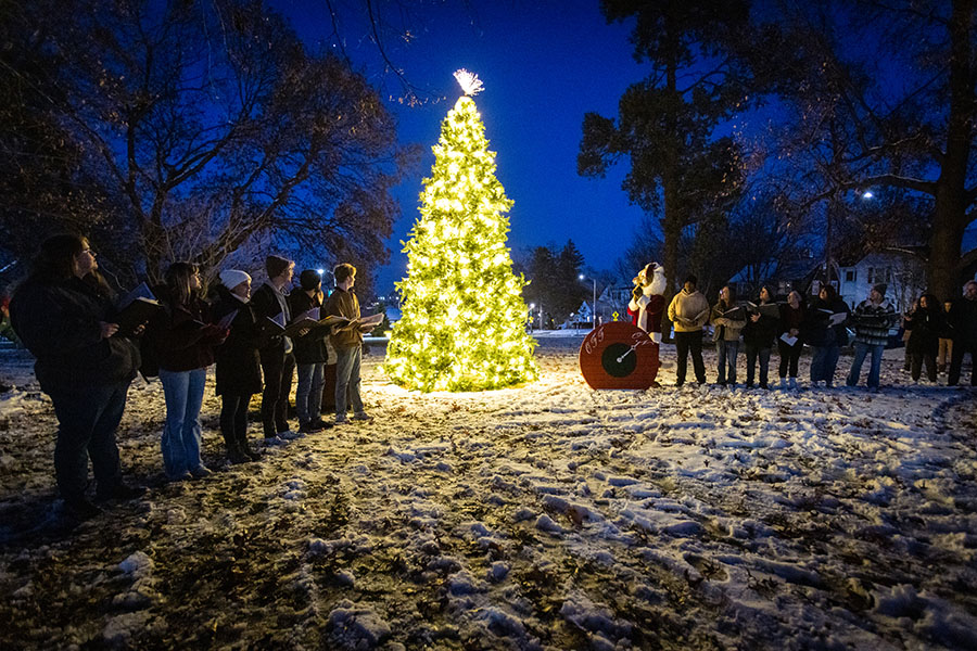 The Madraliers sang after Bobby Bearcat turned a switch to light a Christmas tree Tuesday night on the lawn of the Thomas Gaunt House.