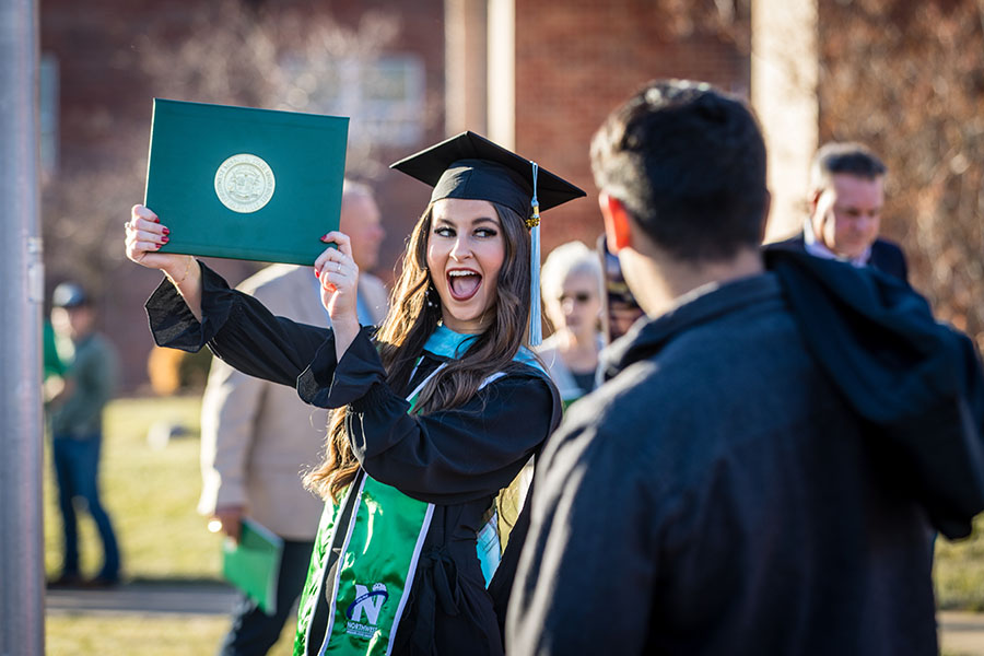 A Northwest graduate flashes her diploma cover after one of the University's commencement ceremonies on Friday.