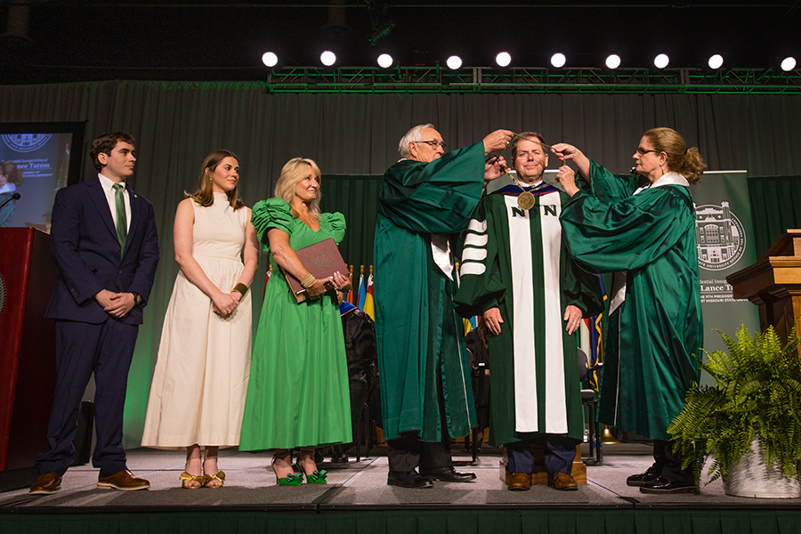 Northwest Regents Mel Tjeerdsma and Roxanna Swaney placed the University's chain of office on Dr. Lance Tatum's shoulders as his family looked on. (Photo by Lauren Adams/Northwest Missouri State University)