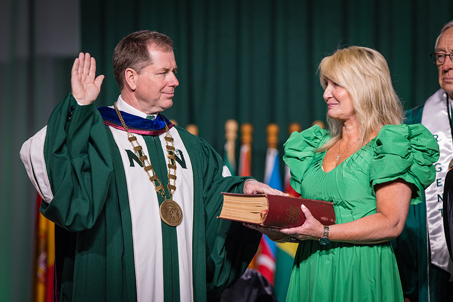 Placing his hand on a family Bible held by his wife, Jill, Dr. Lance Tatum accepted the charge to carry out the duties of Northwest’s president. (Photo by Todd Weddle/Northwest Missouri State University)