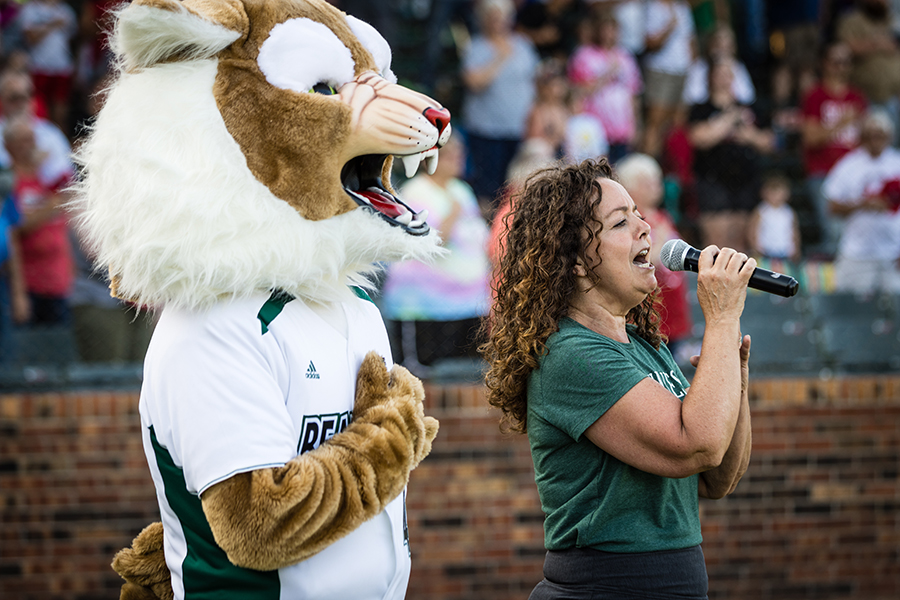 Bobby Bearcat joined Northwest alumna Polly Havard as she sang the national anthem during last year's Northwest Night at the St. Joseph Mustangs. (Photo by Lauren Adams/Northwest Missouri State University)