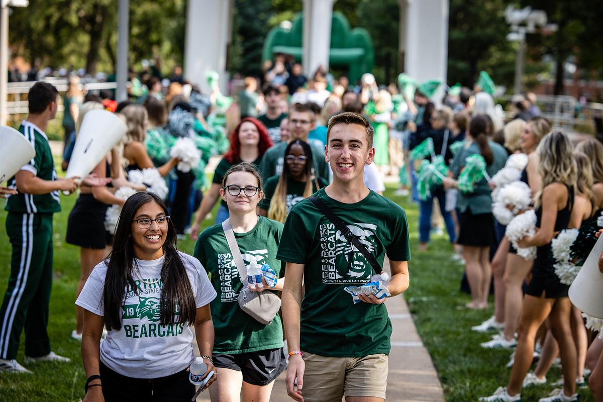 Northwest employees and community members line the sidewalk to welcome new students as they pass under the Bell Tower