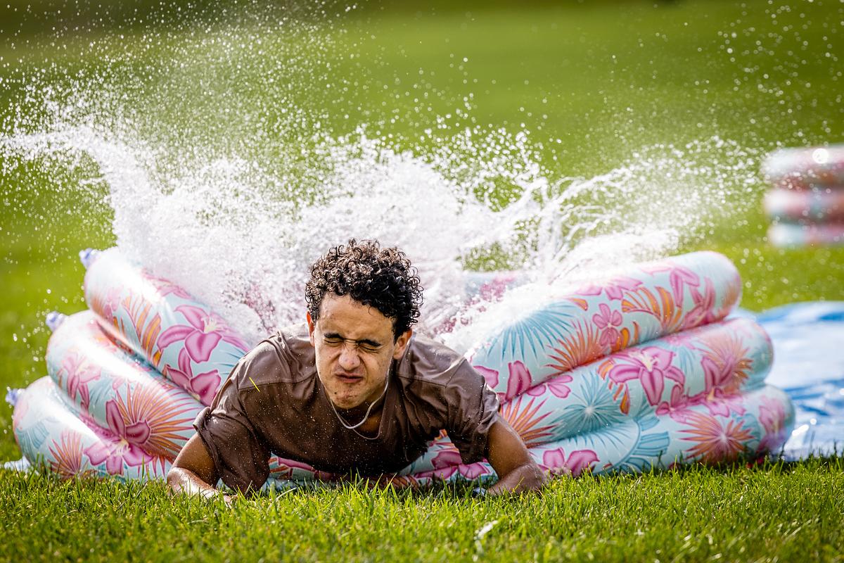 A student slides into a pool of water during Waterslide kickball
